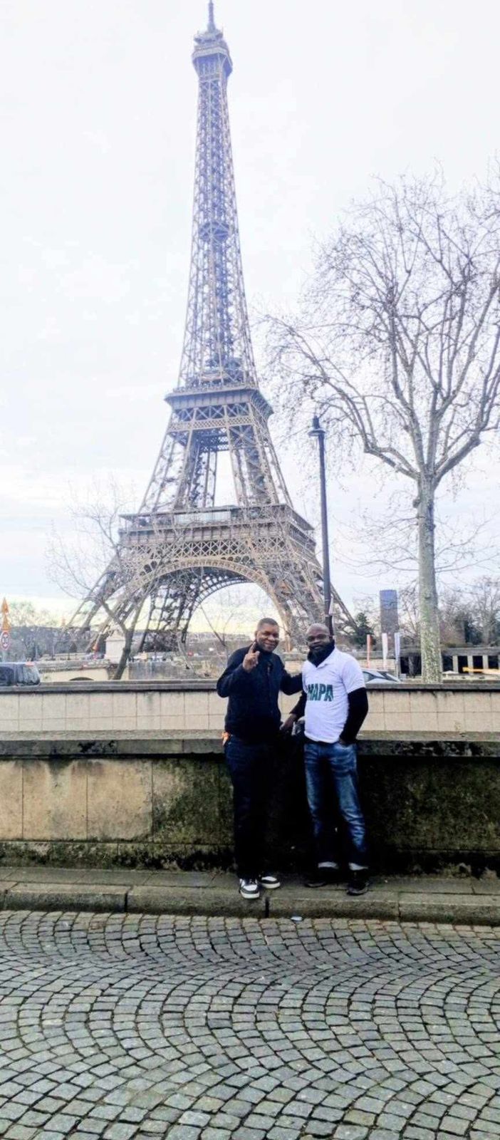 Deux membres de l'association aux couleurs AMAPA devant la tour Eiffel