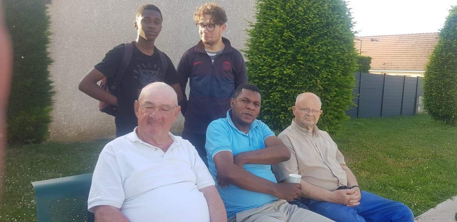 Des aînés, des jeunes et un bénévole de l'association réunis sur un banc à Toury